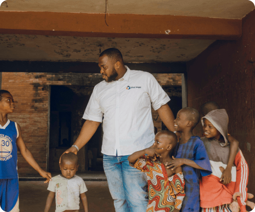 A School-Integral team member standing with children